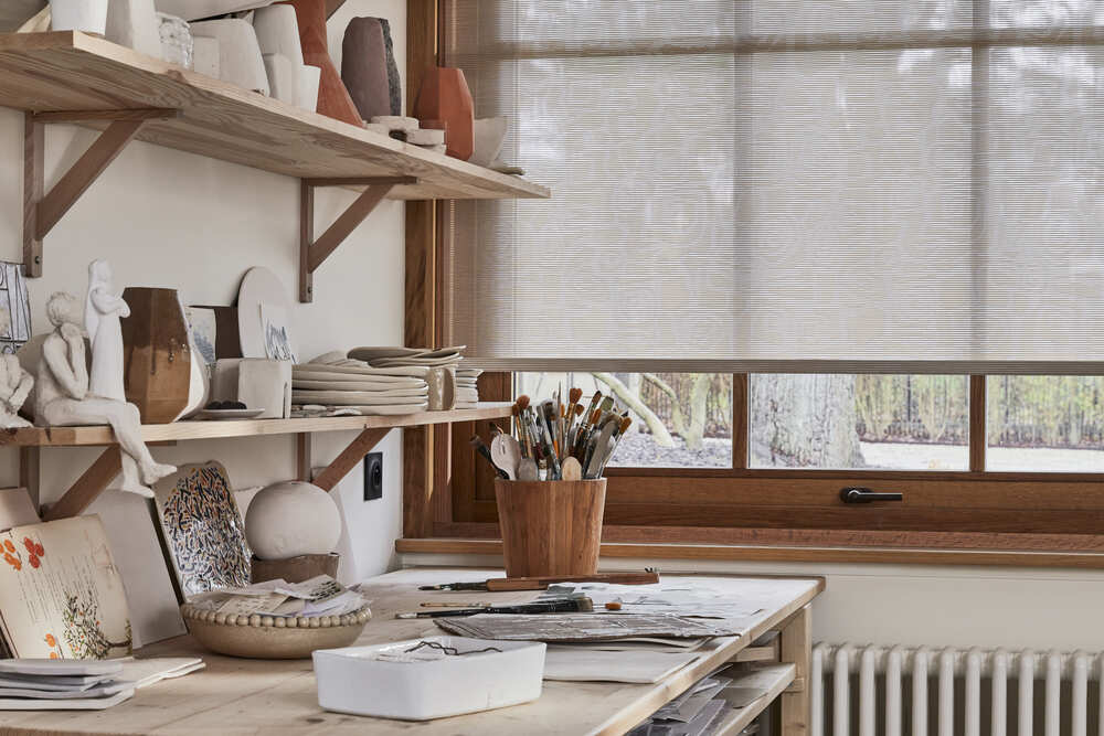 Store enrouleur avec motifs décoratifs blancs dans un atelier d'artiste